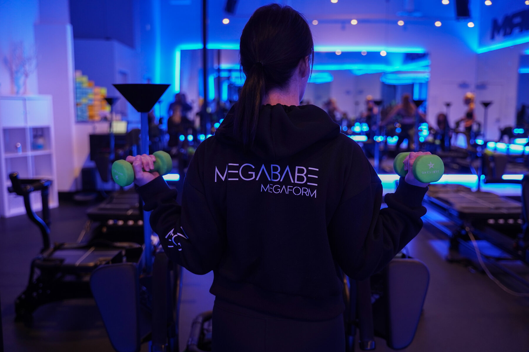 Megaform team member lifting weights in the blue-lit Eugene studio